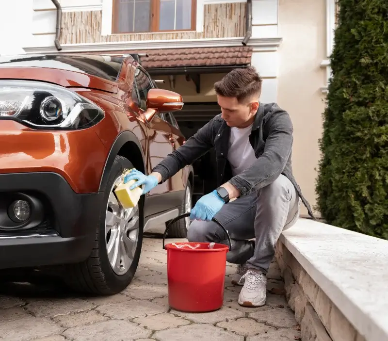 Lavage auto à domicile Auvers-sur-Oise : professionnel intervenant sur un véhicule